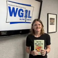 Kayla Whitmer holds a copy of Bite by Bite at the WGIL studio during Galesburg's Morning News