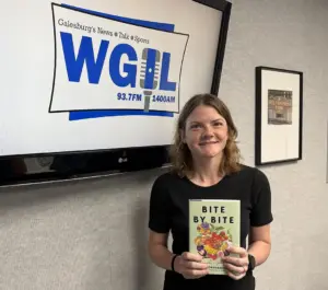 Kayla Whitmer holds a copy of Bite by Bite at the WGIL studio during Galesburg's Morning News