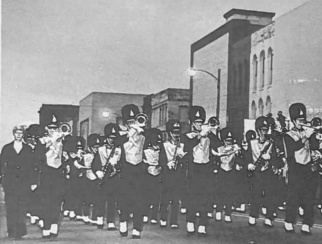 Alt text: The Galesburg High School Marching Streaks march through downtown Galesburg in a parade
