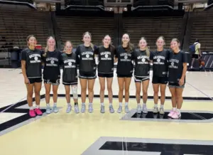 Galesburg girls basketball players posing together on the court during a summer team trip to Purdue