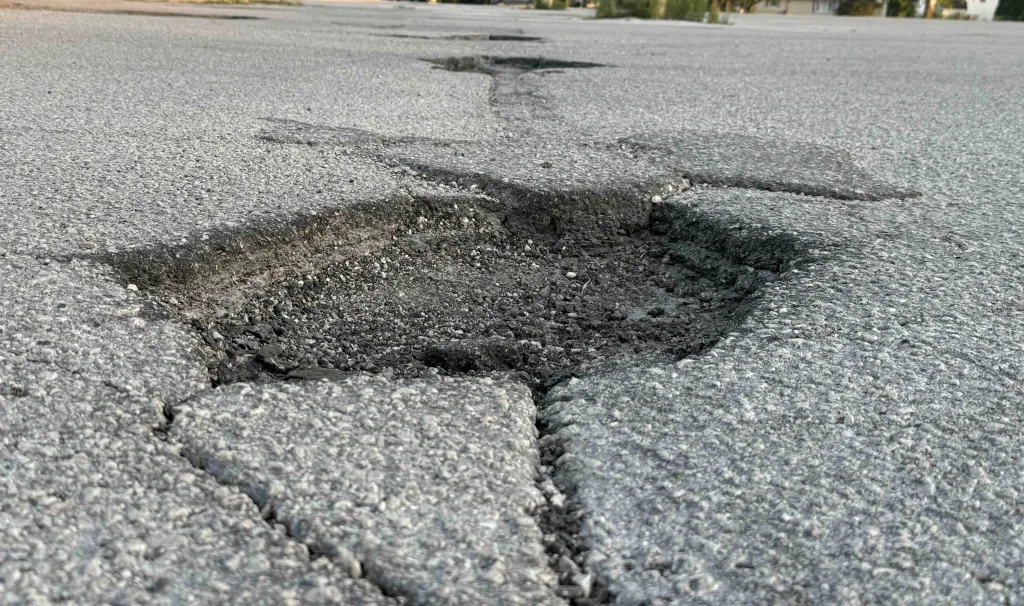 Cracked and crumbling pavement in a Galesburg parking lot