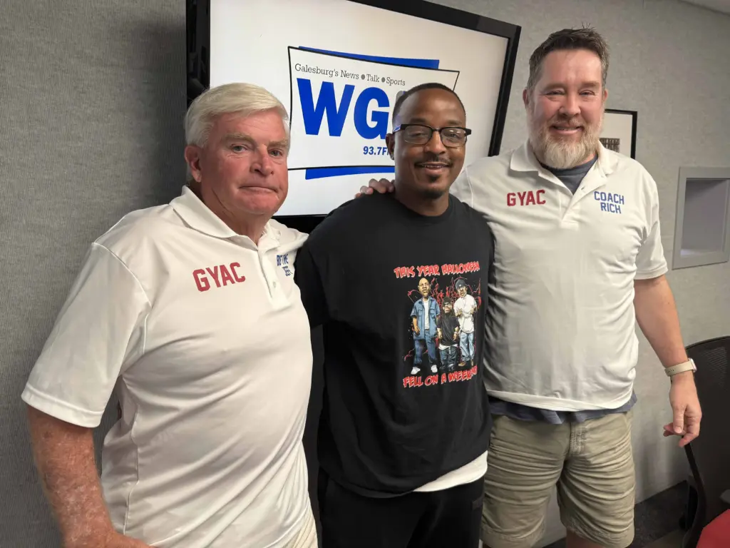 Jeff Hoschek, Terrence Gregory, and Rich Norton of the Galesburg Youth Athletic Club standing together in the WGIL studio.