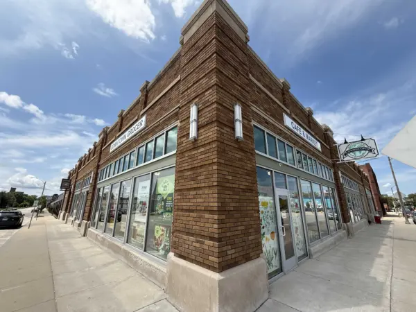 Exterior of the brick building housing Cornucopia Natural Market & Deli, with signage reading "Downtown Grocer" and "Cafe & Market."
