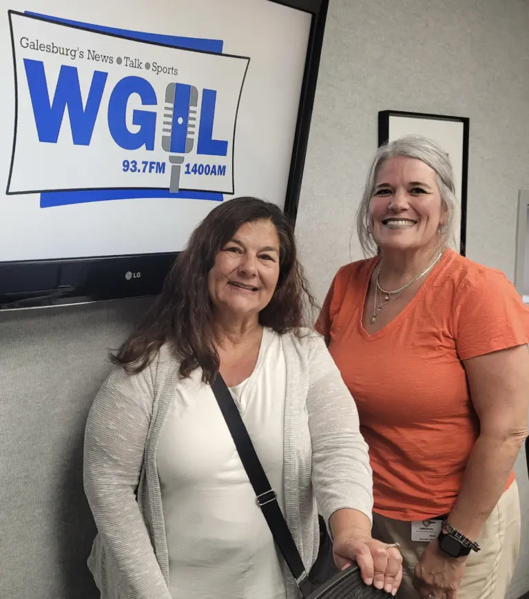 Reina Reyes and Staci Simpson of the Knox Community Health Center standing in front of a WGIL sign