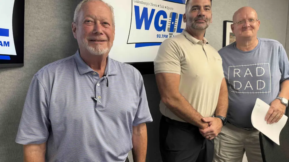 ALT TEXT: Bob Bondi, Steve Gugliotta and Phil Dickinson standing together in front of a WGIL sign