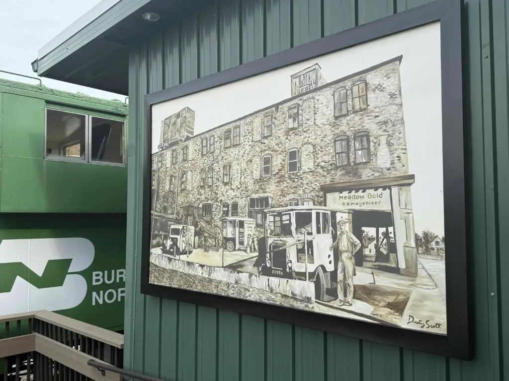 The Meadow Gold Dairy mural mounted on the exterior of Discovery Depot Children's Museum, near the museum's caboose exhibit