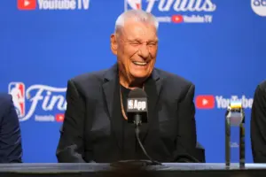 Don Nelson laughing at a podium microphone in front of an NBA Finals backdrop (AP Photo/Kyle Phillips, File)