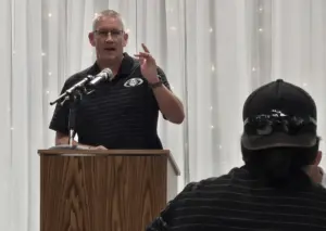 Shawn Hickey speaking at a podium during the Western Big 6 football kickoff banquet
