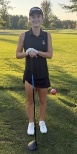 Ella Herchenroder poses with her golf club and ball on the course