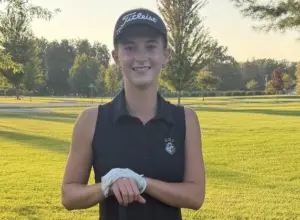 Ella Herchenroder poses with her golf club and ball on the course