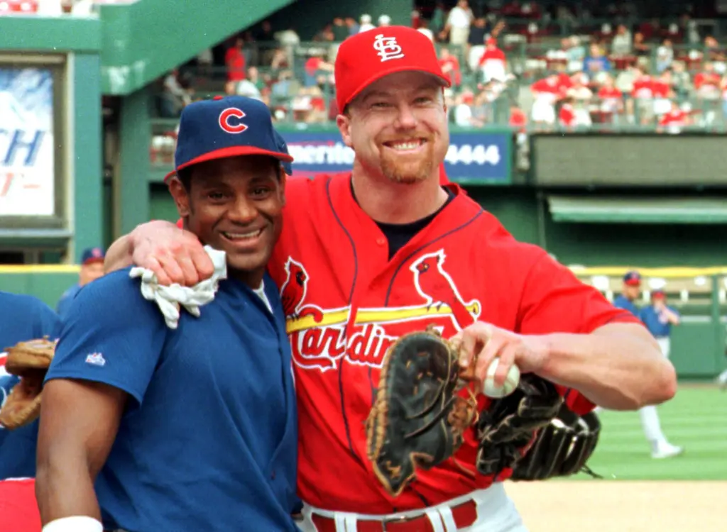 Sammy Sosa and Mark McGwire pose together in their team uniforms in 1998