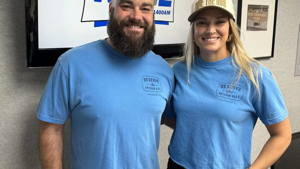 **ALT TEXT:** Blake and Lindsay Benedict in the WGIL studio wearing Reserve Artisan Ales shirts