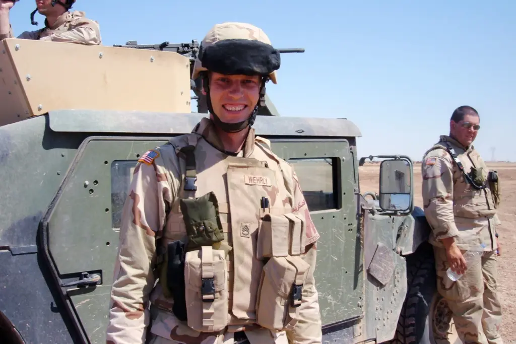 Kyle Wehrly in uniform beside a Humvee in Iraq