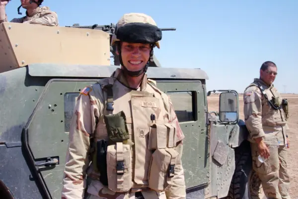Kyle Wehrly in uniform beside a Humvee in Iraq