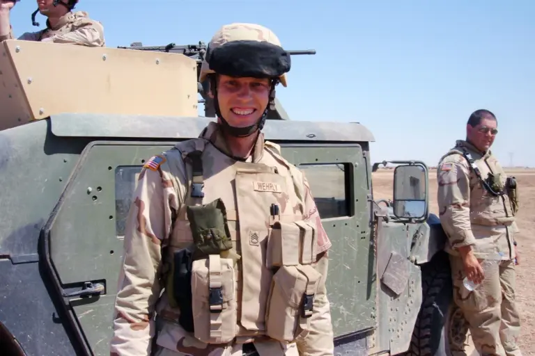Kyle Wehrly in uniform beside a Humvee in Iraq