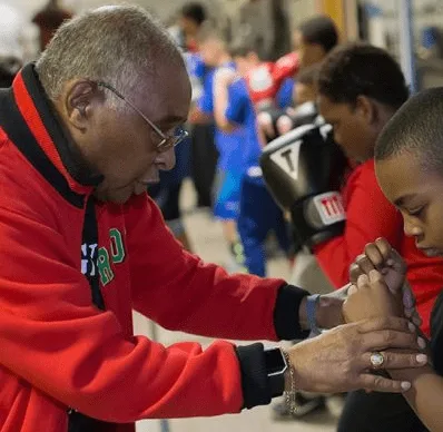 Carlos Duncan wrapping a young boxer's hands at the Galesburg Youth Athletic Club gym