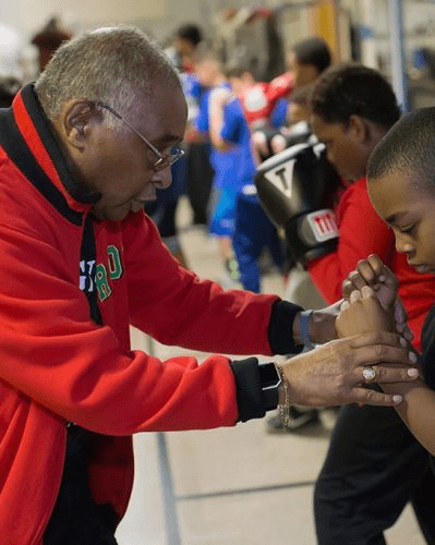 Carlos Duncan wrapping a young boxer's hands at the Galesburg Youth Athletic Club gym