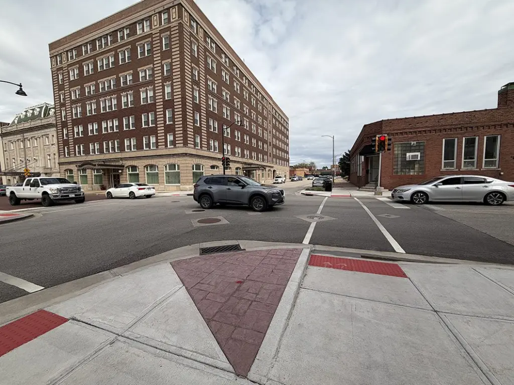 Street view of the Kellogg and Simmons streets intersection in Galesburg, showing a red-brick curb bump-out