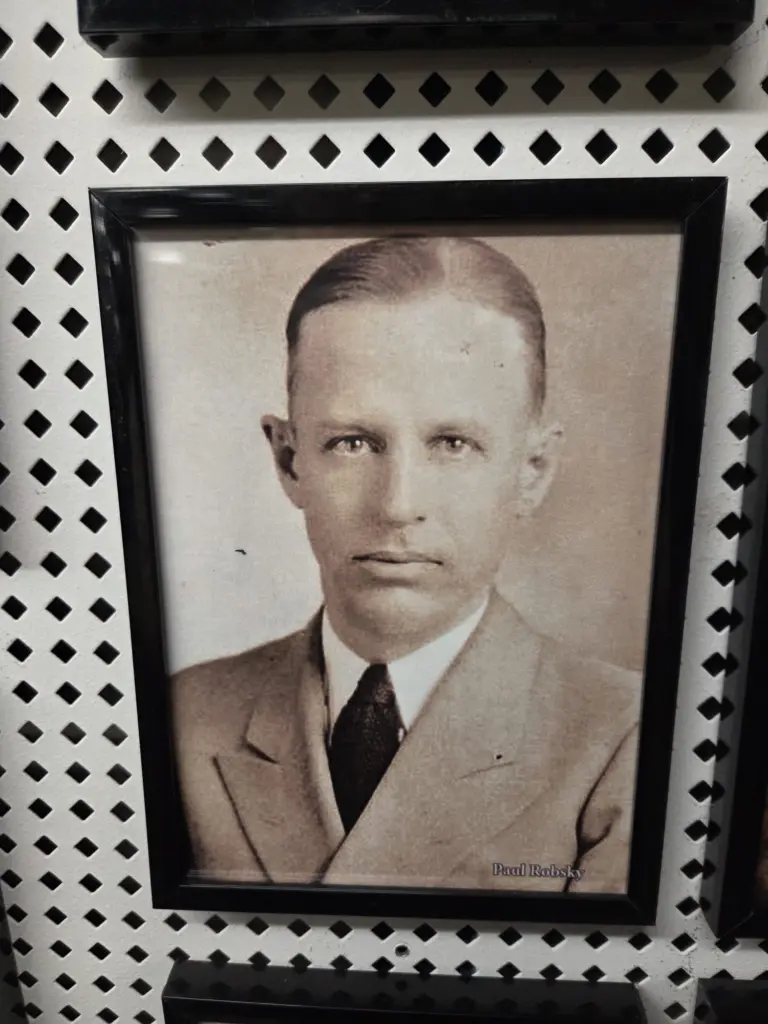 Framed sepia portrait of a young Paul Robsky in a suit and tie