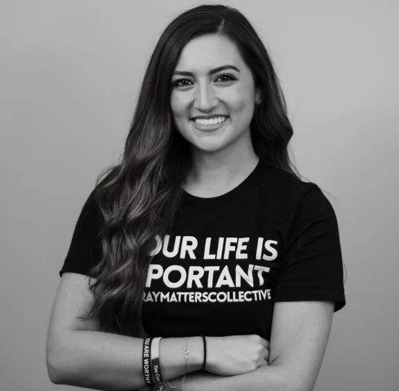 Haley DeGreve smiling with arms crossed, wearing a black Gray Matters Collective T-shirt