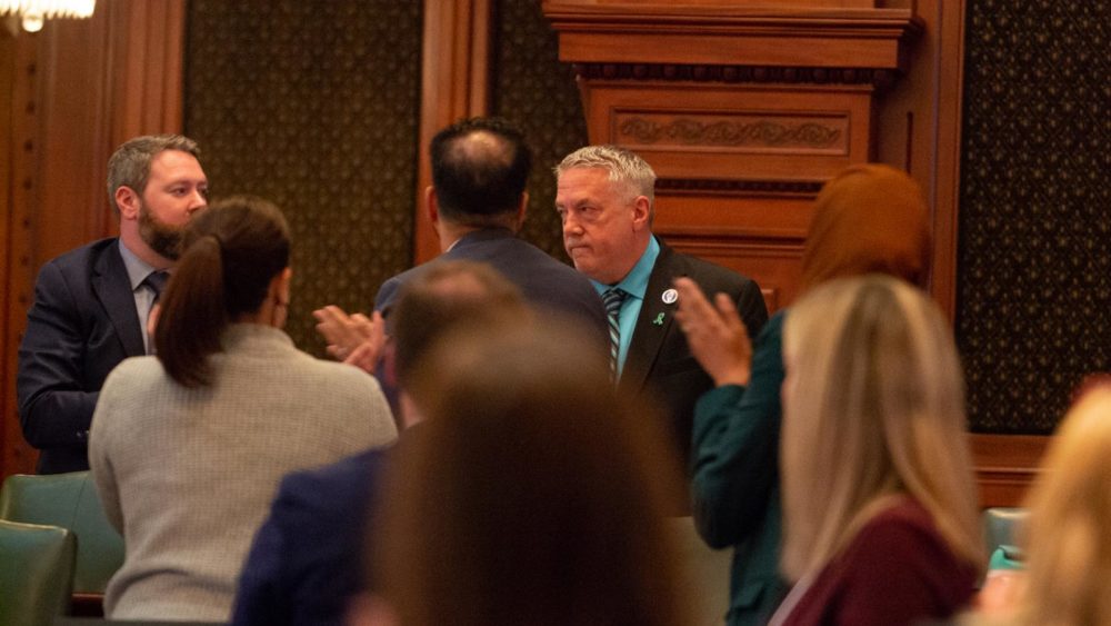 Rep. Gregg Johnson, D-East Moline, receives applause from his House colleagues after sharing the story of how his mother died from preeclampsia in 1972 – just six months before the U.S. Supreme Court’s landmark ruling legalizing abortions. (Capitol News Illinois photo by Jerry Nowicki) 