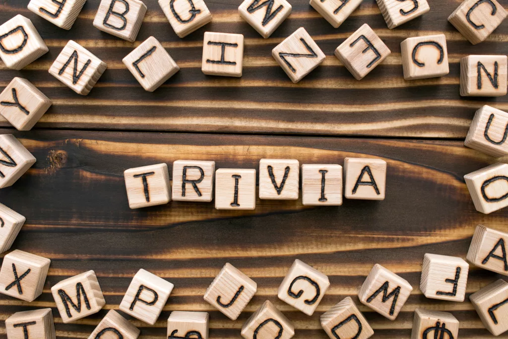 trivia - word from wooden blocks with letters, unimportant concept, random letters around, top view on wooden background