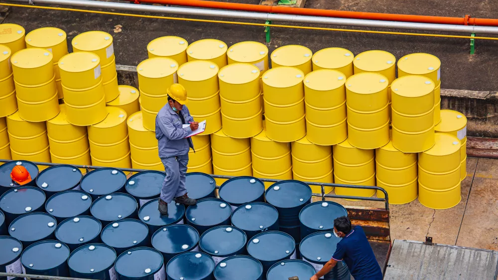 Male worker inspection record drum oil stock barrels yellow vertical or chemical for transportation truck male in the industry.
