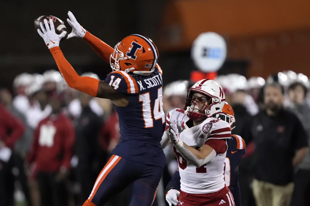 Illinois defensive back Xavier Scott intercepts a pass intended for Nebraska wide receiver Alex Bullock during the second half of an NCAA college football game Friday, Oct. 6, 2023, in Champaign, Ill. (AP Photo/Charles Rex Arbogast)