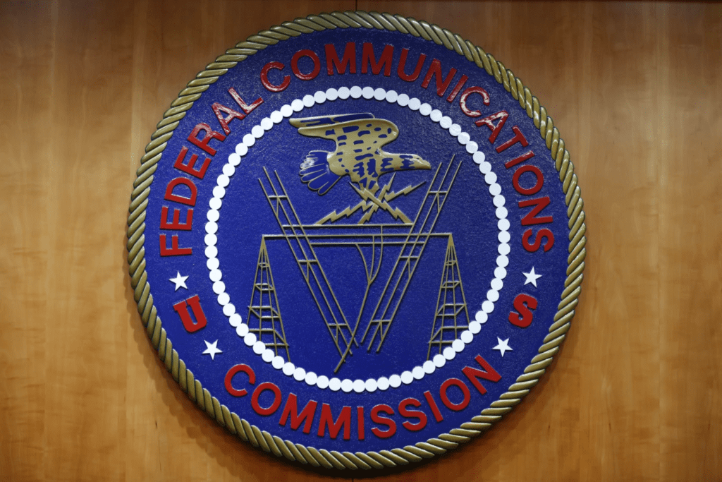 FILE - The seal of the Federal Communications Commission (FCC) is seen before an FCC meeting to vote on net neutrality, Dec. 14, 2017, in Washington. The Federal Communications Commission is outlawing robocalls that contain voices generated by artificial intelligence. The decision sends a clear message that exploiting the technology to scam people and mislead voters won’t be tolerated. (AP Photo/Jacquelyn Martin, File)