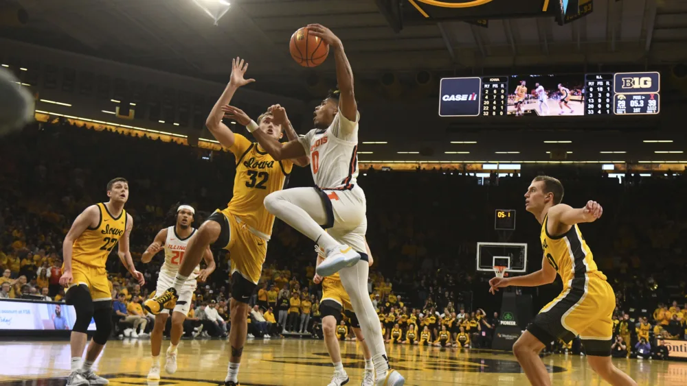 Illinois guard Terrence Shannon Jr. (0) drives to the basket under pressure from Iowa forward Owen Freeman (32) during the first half of an NCAA college basketball game, Sunday, March 10, 2024, in Iowa City, Iowa. (AP Photo/Cliff Jette)