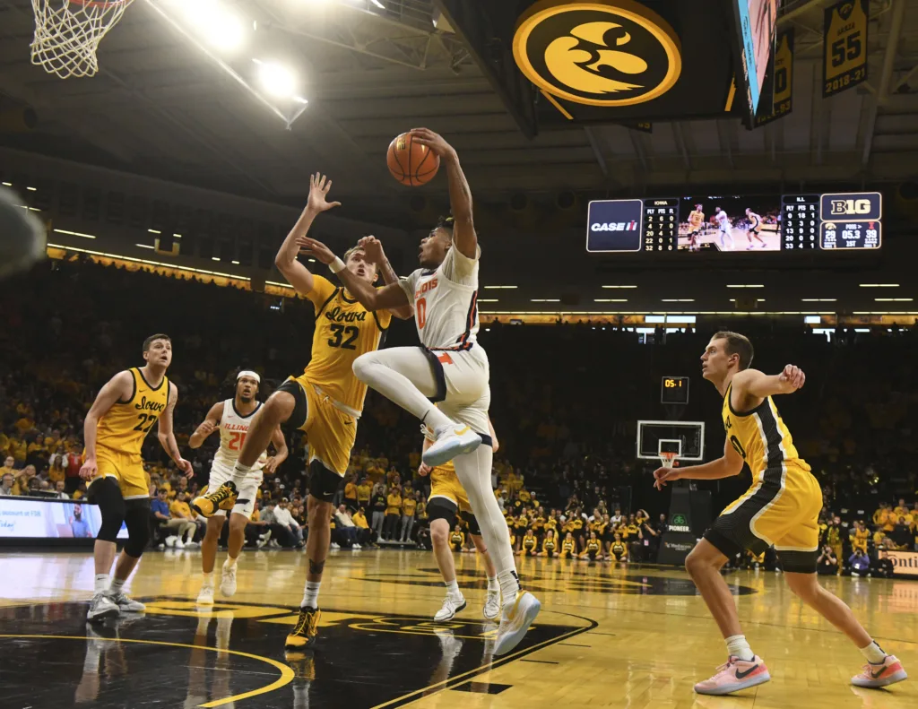 Illinois guard Terrence Shannon Jr. (0) drives to the basket under pressure from Iowa forward Owen Freeman (32) during the first half of an NCAA college basketball game, Sunday, March 10, 2024, in Iowa City, Iowa. (AP Photo/Cliff Jette)