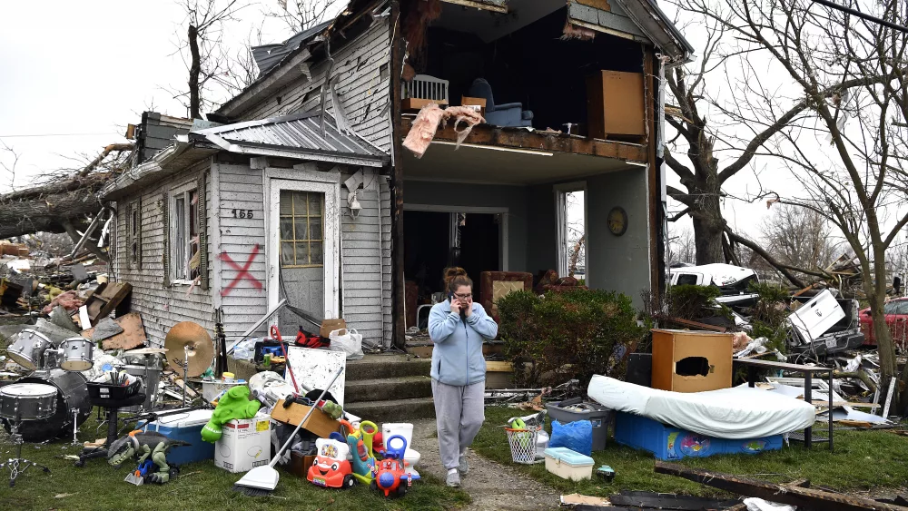 Brittany Oakley checks in with relatives outside of what is left of her home in Lakeview, Ohio., Friday, March 15, 2024. Severe storms with suspected tornadoes have damaged homes and businesses in the central United States. (AP Photo/Timothy D. Easley)