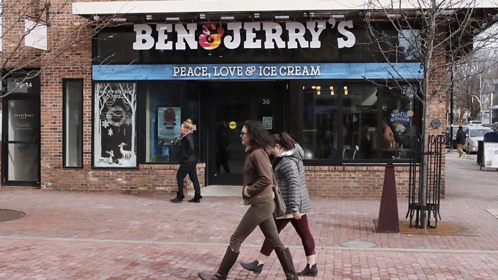 FILE - Pedestrians walk on Church St., past the Ben & Jerry's shop, in Burlington, Vt., Wednesday, March 11, 2020. Unilever, the company that makes Ben & Jerry’s ice cream, Dove soaps and Vaseline, said Tuesday, March 19, 2024, that it is cutting 7,500 jobs and spinning off its ice cream business to reduce costs and boost profits. (AP Photo/Charles Krupa, File)