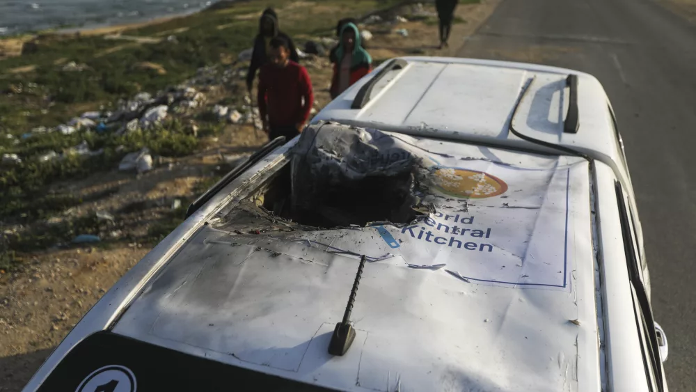 Palestinians inspect a vehicle with the logo of the World Central Kitchen wrecked by an Israeli airstrike in Deir al Balah, Gaza Strip, Tuesday, April 2, 2024. A series of airstrikes killed seven aid workers from the international charity, leading it to suspend delivery Tuesday of vital food aid to Gaza. (AP Photo/Ismael Abu Dayyah)