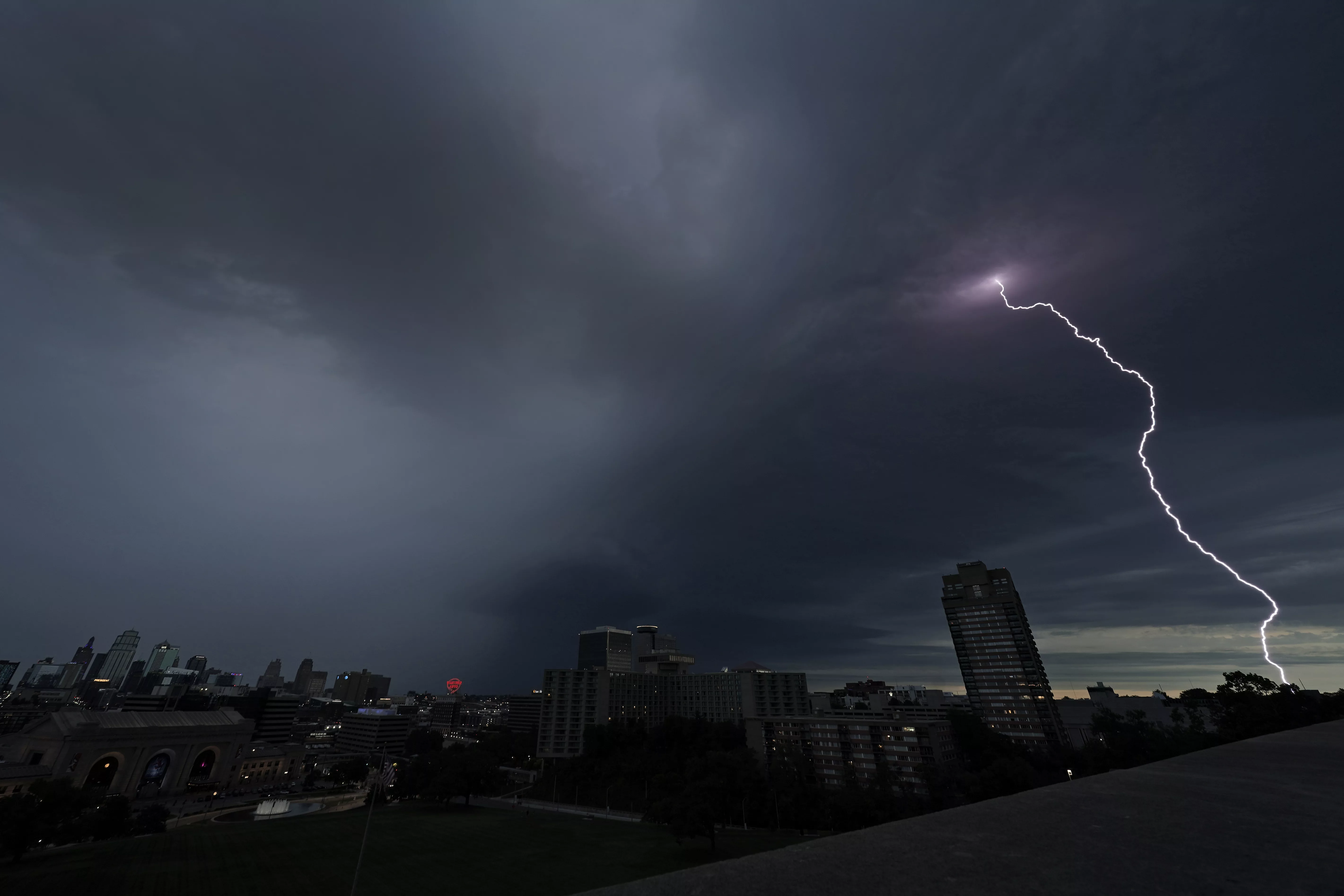 FILE - Lightning strikes in the distance as a thunderstorm passes over downtown Kansas City, Mo., July 30, 2023. Tens of millions of Americans stretching from Lincoln, Neb., to Baltimore could face strong thunderstorms Monday night, April 15, 2024, through Wednesday, April 17, with tornadoes possible in some states. (AP Photo/Charlie Riedel, File)