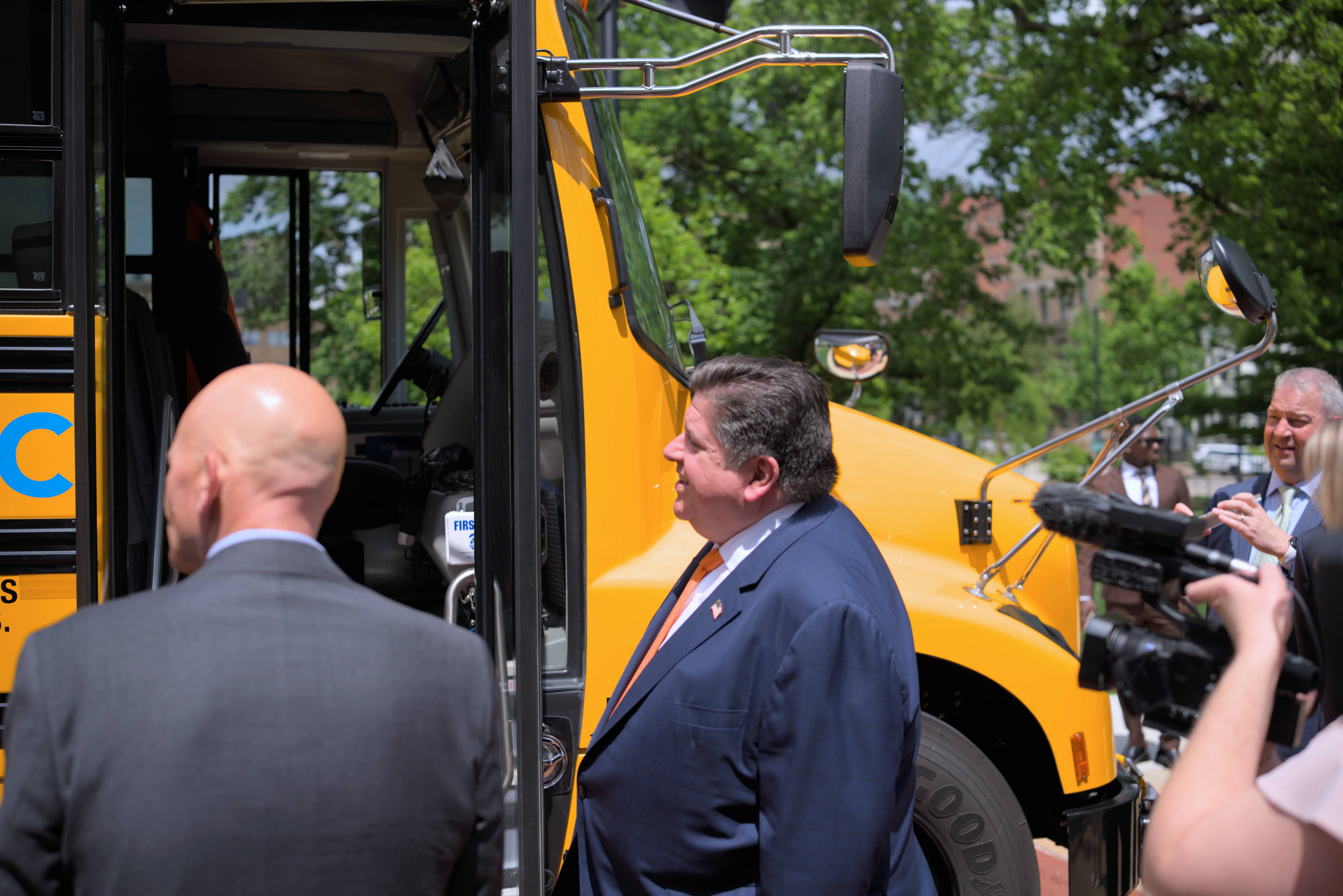 Governor Pritzker in front of electric school bus