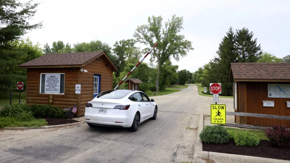 A car enters the gated community of Lost Lake near Dixon, Ill., Wednesday, June 12, 2024. Authorities said three sheriff's deputies were shot while responding to a report that someone inside a home in the Lost Lake community was threatening to kill themself or others. The suspect was also wounded. (AP Photo/Teresa Crawford)