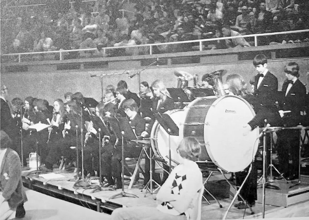 Bob Prusator’s 1982-83 Tiskilwa Indians made history by becoming the school’s first and only basketball team to reach the state tournament.The Indians were not the first Tiskilwa group to play at state, however.In 1976, the Tiskilwa pep band under the direction of Jim Jones was selected as the first high school band to play at the state tournament. The Tiskilwa band was chosen over 60 other schools who auditioned for the honor.Dressed in formal attire, the 34 members of the award-winning Tiskilwa band came equipped with a 36-song list that included fan favorites like “Proud Mary” as they serenaded fans throughout Friday’s quarterfinal games.The IHSA is getting the old band back together. Members of that Tiskilwa band will make an encore this week to mark its 50th anniversary of its record-making performance. Twenty-four of the 32 living band members are expected to be in attendance this Thursday in Champaign, which will be 50 years to the day of their performance.In addition, the band from Princeton High School, which took in Tiskilwa students in 1996 when it dissolved, will commemorate the anniversary by playing at the state tournament on Thursday.Jones joked that he “doesn’t know how they did this, and I don’t want to know,” but is thrilled that the Princeton band is playing that day.“Princeton is doing the actual work, because that’s their age. And our age is to say, ‘Atta boy,’ ” he said.The Tiskilwa band members will be brought out at halftime of the first 2A semifinal Thursday, approximately at 3:15 p.m. Jones thanked Larry Magnuson of the Tiskilwa Museum for proposing the band’s 50th anniversary celebration to the IHSA.Phil Kaufmann, who played the clarinet for the Tiskilwa band, said it will be fun to return to state and reminisce.“At the time, I don’t recall that this was a first time event to have a band there. But leave it to Mr. Jones, who said, ‘Wait a minute, music’s got to be recognized at the state level, too,’ ” he said.After playing in the tiny Tiskilwa gym, Kaufman remembers how enormous Assembly Hall was.“I remember walking in there and thinking, ‘Wow, this is a pretty big room. I think I can play as loud as I want. Nobody’s going to complain,’ ” he said. “We could kind of rock the rafters (at Tiskilwa), but the rafters were pretty high down there.”Kaufmann said part of the reason he wants to go to Champaign is to express appreciation for the music department they had at Tiskilwa. “Mr. Jones and Mrs. Hamilton worked to make opportunities for us to experience things not everybody got to do in high school,” he said.Tiskilwa had an enrollment of 166 students in 1976, of which a little more than 20% participated in band.Other members of the 1976 Tiskilwa band were Curtis Albrecht, Barbara Ary, Sally Ary, Laura Baldwin, David Bitting, Kim Brokaw, Cathy Cain, Sharon Cooper, Chris Cotter, John Cotter, Joe Jamison, Julie Jamison, Monica Jamison, Brian Johnson, Paul Kaufmann, Phyllis Kaufmann, Don Longman, Laurie Miller, Rex Ringenberg, Laurie Rossman, Michelle Rossman, Mark Schultz, Sherrie Sendelbach, Sandra Shepard, Mark Shull, Jennifer Smith, Julie Smith, Sally Snow, Abby Stacker, Muriel Walters, Cindy Walton, Rhonda Workman and David Yepsen.Jones said that state performance put a lot of pressure on the Tiskilwa band to live up to its reputation.“It brought a tremendous amount of publicity and good to the school and community,” he said. “Quite frankly, it put some burden on the band’s shoulders to keep the quality of performance progressing and the concerts and performance that the audiences like. We just felt like we had to keep it going.”As a result of the Tiskilwa band’s commitment to excellence, it won the right to play at state again in 1978 and 1984 (the girls tournament).Band was introduced at Tiskilwa in 1934 by Fred Weber, a nationally known composer and publisher. The Tiskilwa band won first at the State Music Contest for the two years leading into their 1976 state performance.Jones, who came to Tiskilwa after graduating from Illinois State University in 1968, was a member of the University of Illinois Rose Bowl band in 1964. “I was lucky enough to get a job in Tiskilwa that had a long, long history and appreciation of music. And it continues to this day now at Princeton,” he said.