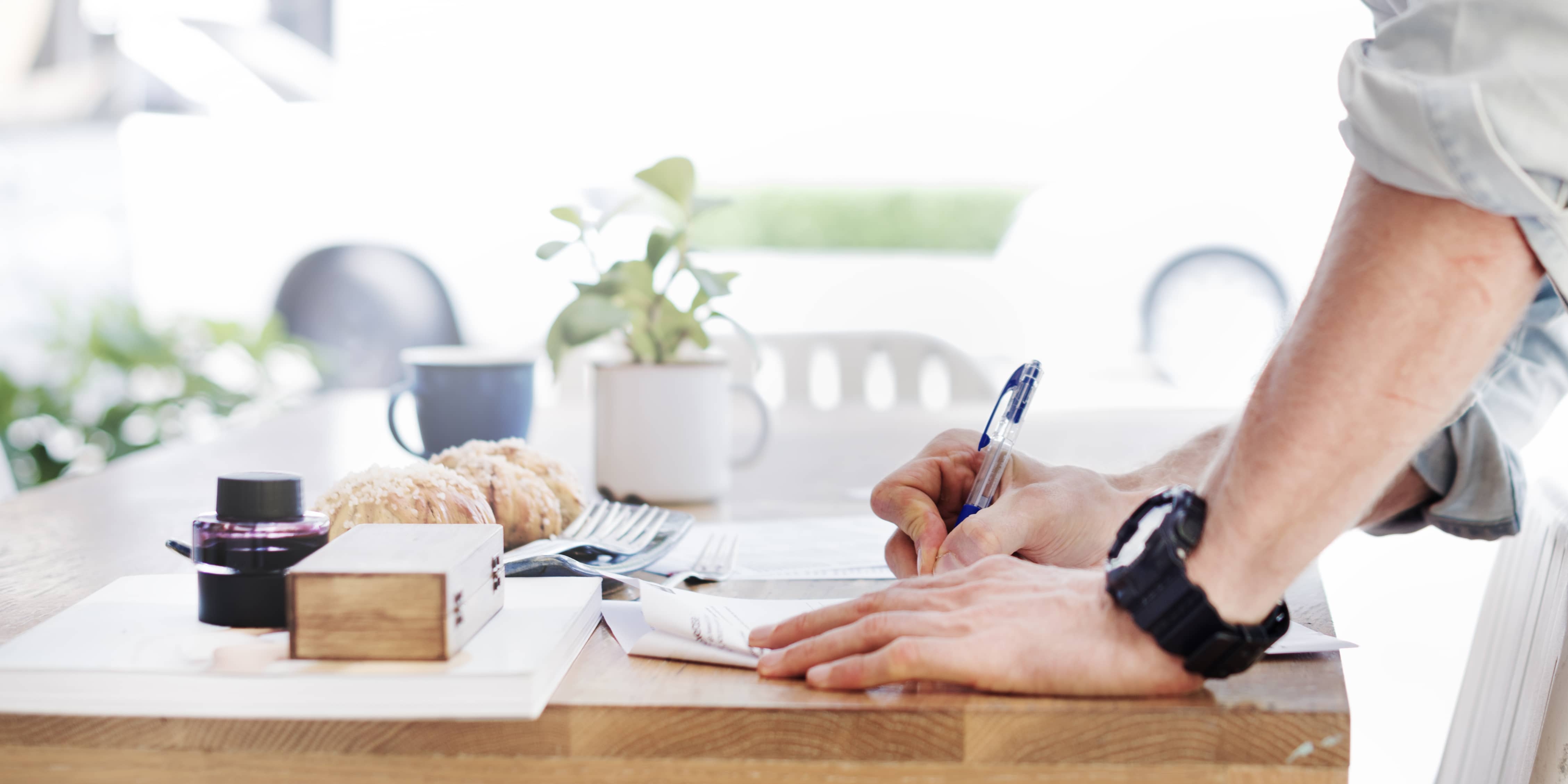 man-writing-document-dinning-table-concept