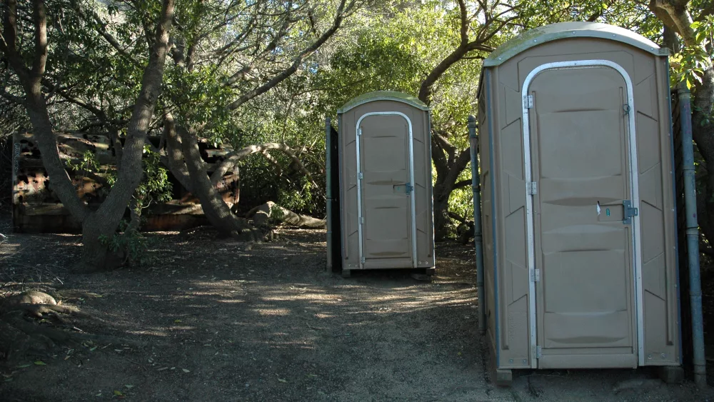 old-tank-held-back-by-trees-2-porta-potties-for-relief-privacy-trail-gray-whale-cove-northern-california-usa
