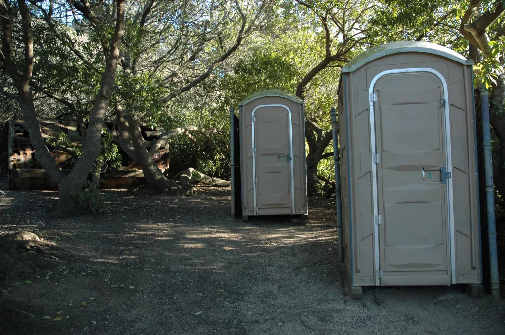 old-tank-held-back-by-trees-2-porta-potties-for-relief-privacy-trail-gray-whale-cove-northern-california-usa