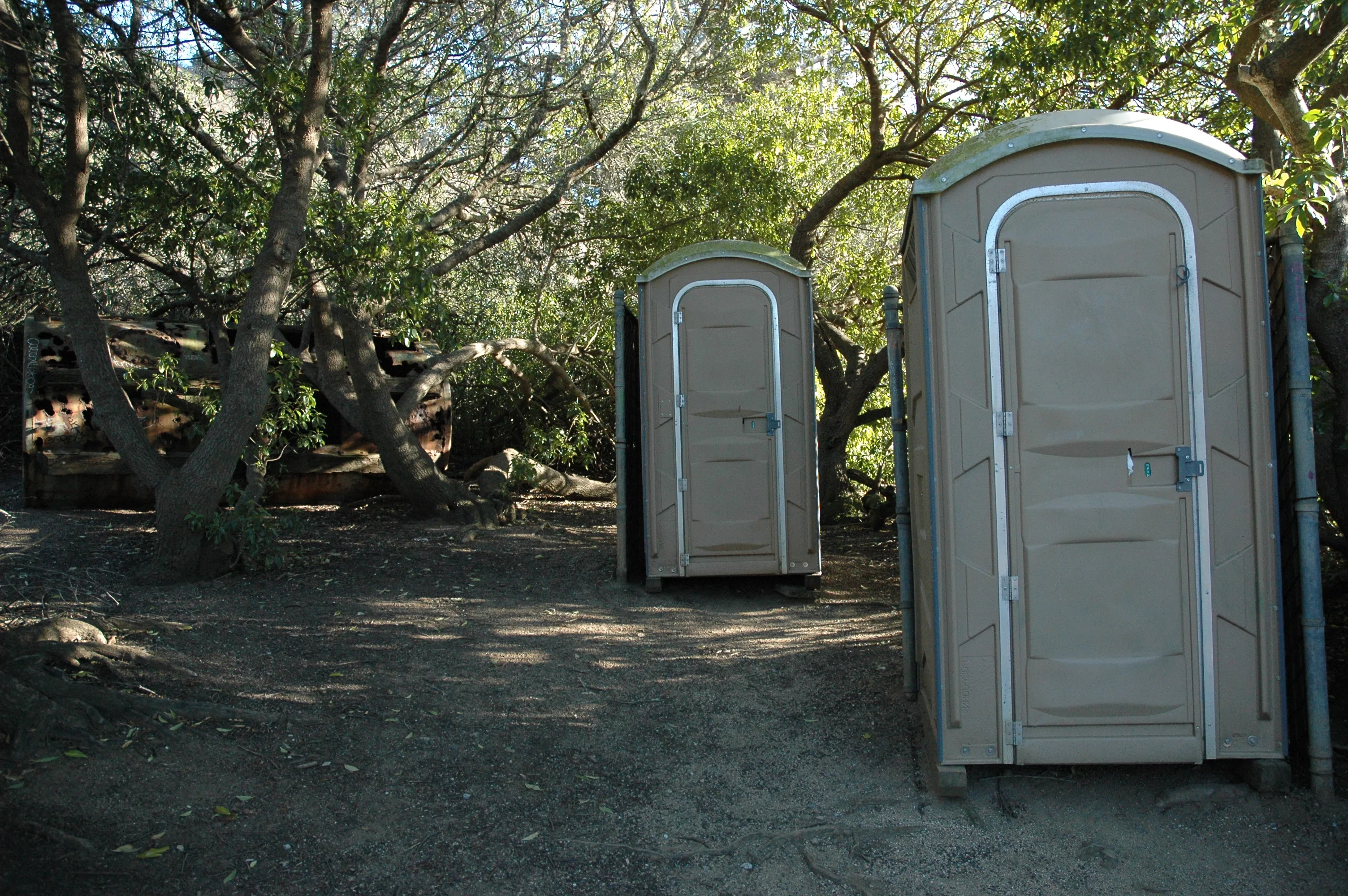old-tank-held-back-by-trees-2-porta-potties-for-relief-privacy-trail-gray-whale-cove-northern-california-usa