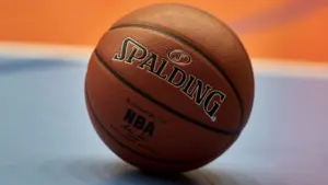 Gdansk^ Poland - 08 02 2024: Close-up of a Spalding NBA basketball resting on a blue and orange court^ focusing on the texture of the ball and the surrounding vibrant colors of the court.