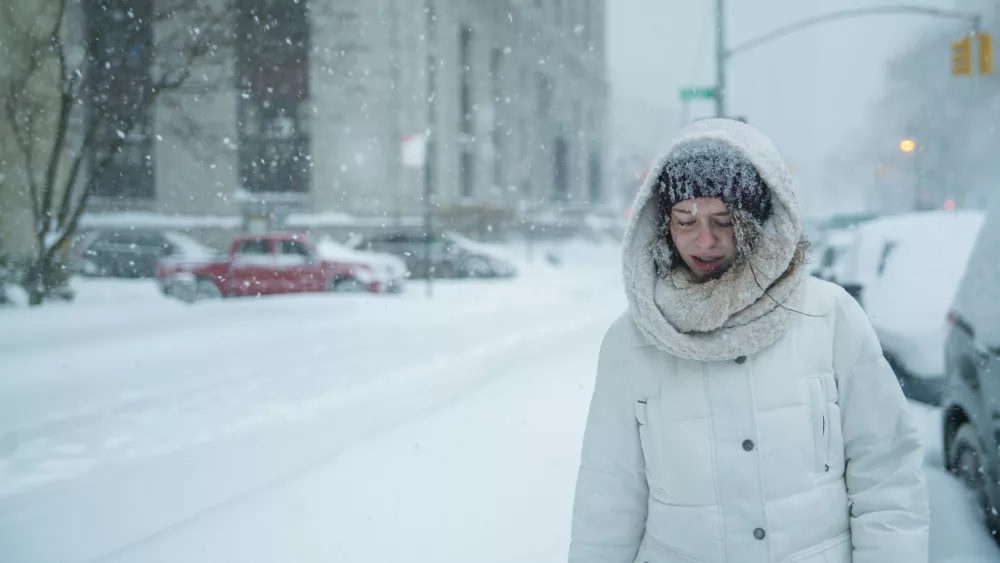 Teenager girl walks under snowfall at the street in Manhattan, New York City, NY, during the snowstorm Jonas. Photo Credit: Getty Images