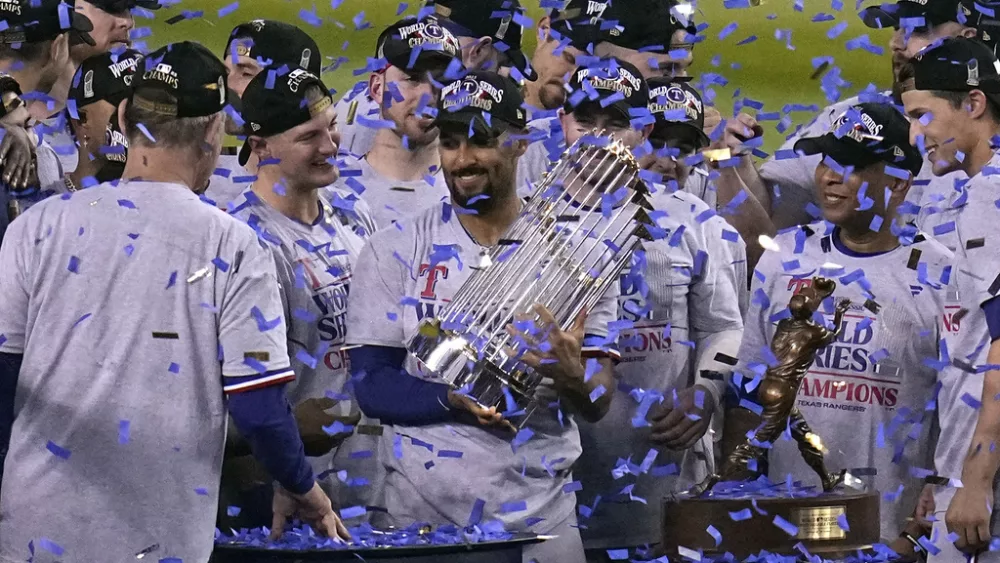 Texas Rangers' Marcus Semien holds the trophy as the Texas Rangers celebrate after winning Game 5 of the baseball World Series against the Arizona Diamondbacks Wednesday, Nov. 1, 2023, in Phoenix. The Rangers won 5-0 to win the series 4-1. (AP Photo/Gregory Bull)