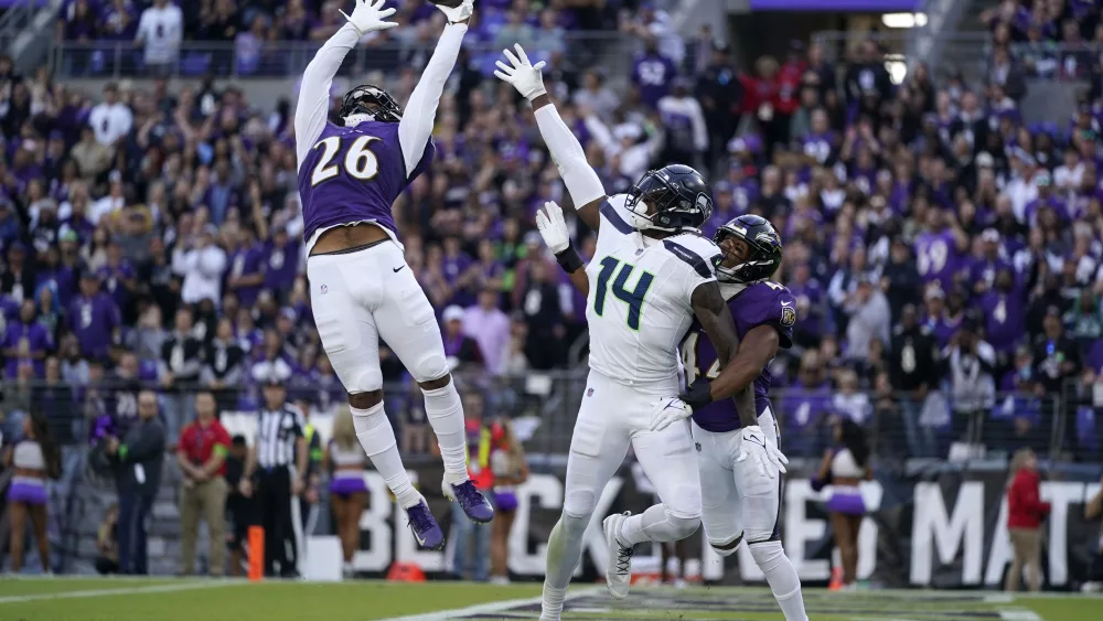 Baltimore Ravens safety Geno Stone (26) and cornerback Marlon Humphrey, right, break up a pass intended for Seattle Seahawks wide receiver DK Metcalf (14) during the second half of an NFL football game, Sunday, Nov. 5, 2023, in Baltimore. (AP Photo/Alex Brandon)