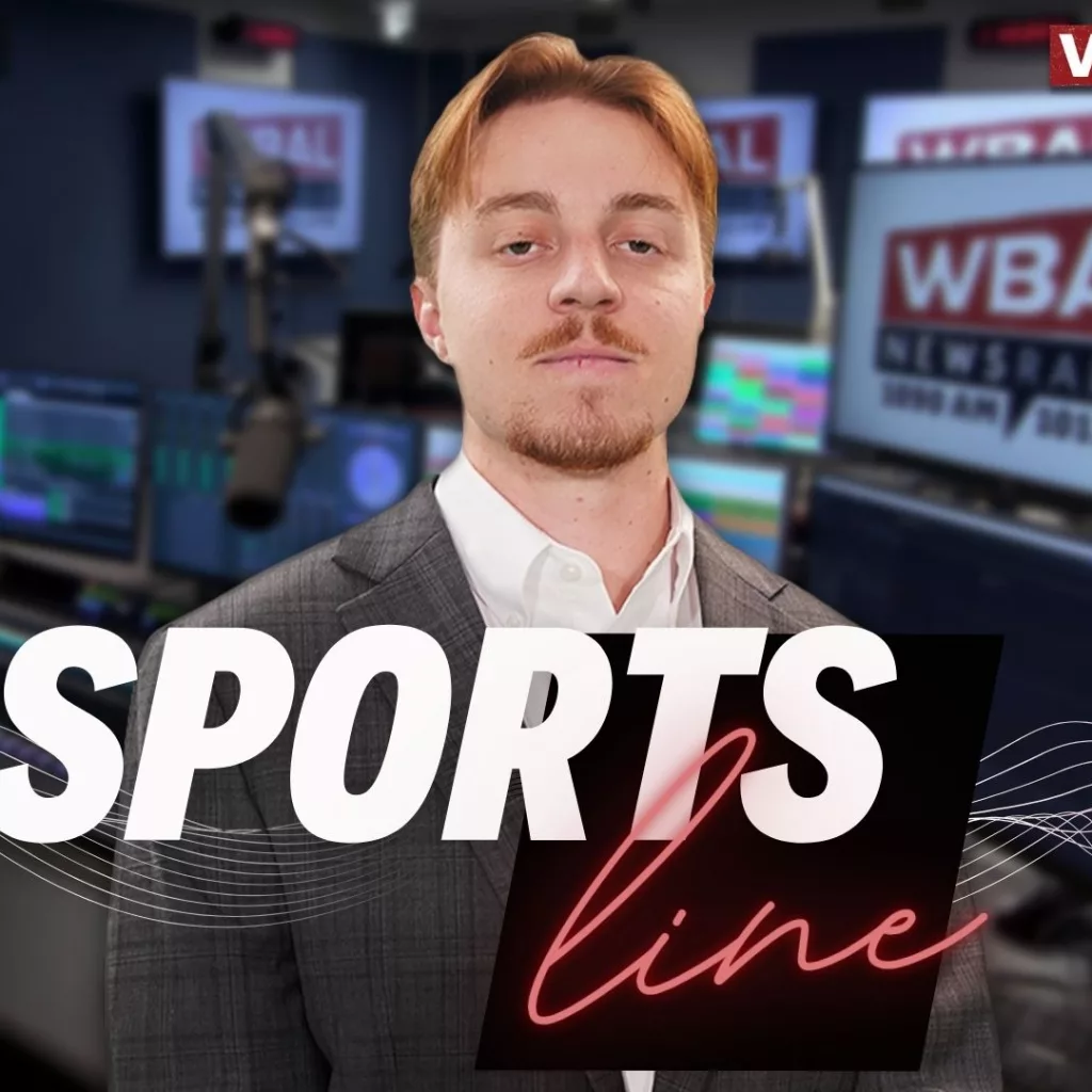 WBAL NewsRadio's Nick Testoni, reporter and host of Saturday's talk show, Sportsline. Nick stands in the WBAL Radio studio in a sports jacket with a straight face.