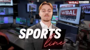 WBAL NewsRadio's Nick Testoni, reporter and host of Saturday's talk show, Sportsline. Nick stands in the WBAL Radio studio in a sports jacket with a straight face.