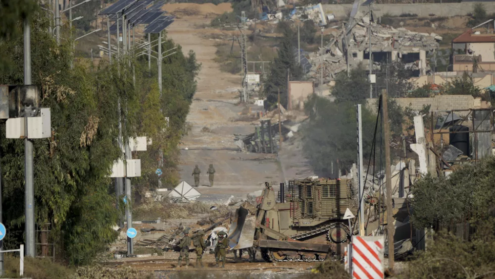 Israeli soldiers stand on Salah al-Din road in central Gaza Strip on Friday, Nov. 24, 2023, as the temporary ceasefire went into effect. (AP Photo/Hatem Moussa)