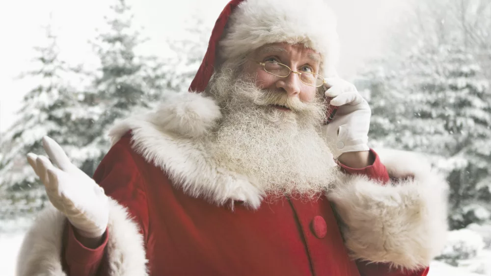 Santa Claus using mobile phone, close-up - stock photo